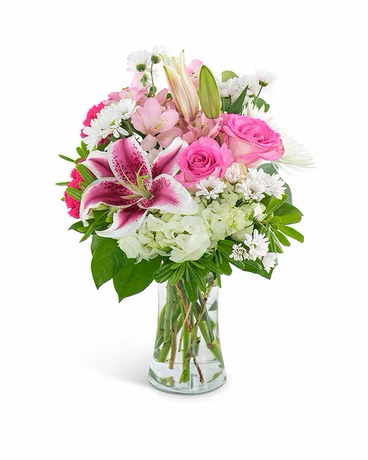 Hand-tied bouquet of pink lilies, roses, and white daisies in a glass vase